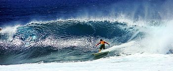 Surfer in Hawaii Surfer reitet eine Welle im blauen Ozean in Hawaii