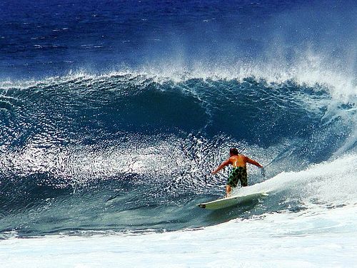 Surfer reitet eine Welle im blauen Ozean in Hawaii