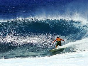 Surfer reitet eine Welle im blauen Ozean in Hawaii