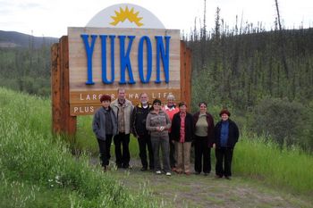 Reisegruppe vor einem Yukon-Schild